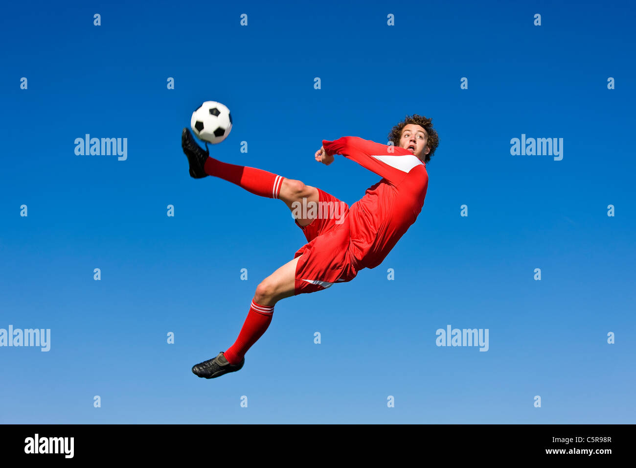 Un joueur de soccer de volée la balle. Banque D'Images