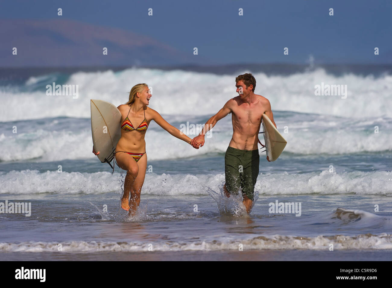 Un couple s'amusant dans les vagues. Banque D'Images