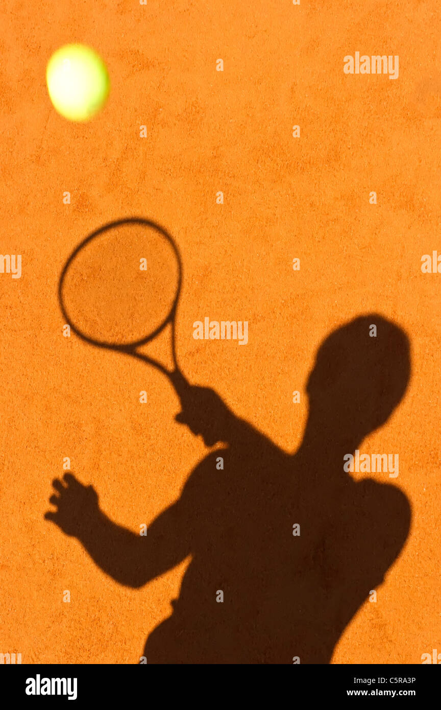 La silhoute d'un joueur de tennis ball retour. Banque D'Images