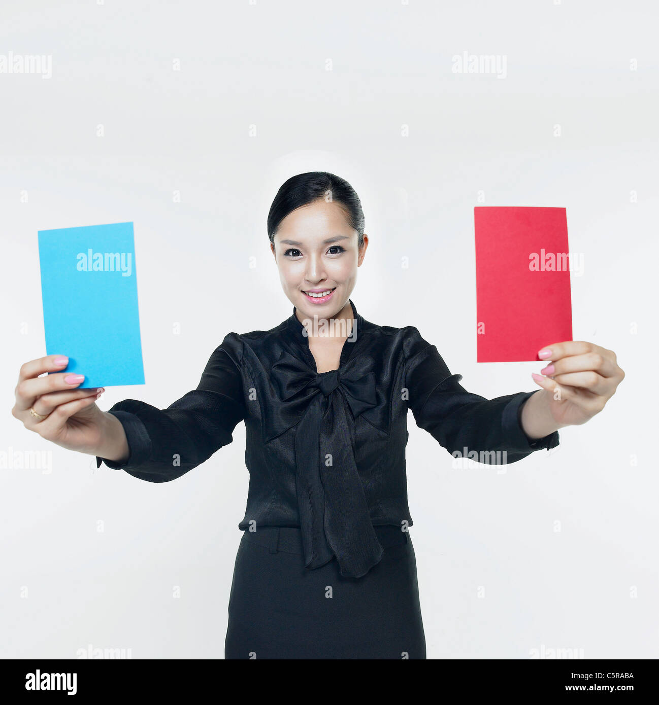 Une femme tenant une carte rouge et une carte bleu Banque D'Images