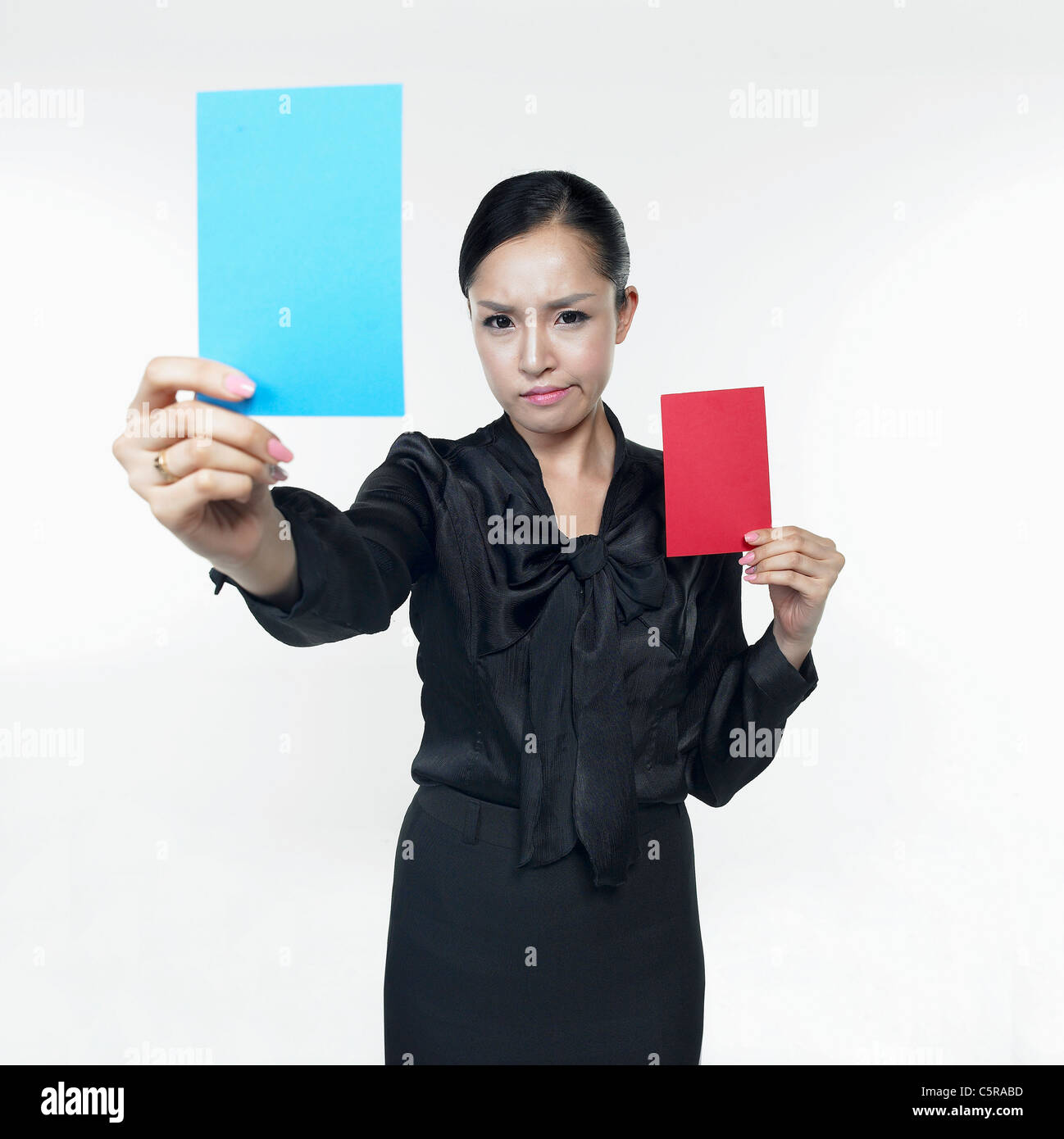 Une femme tenant une carte rouge et une carte bleu Banque D'Images