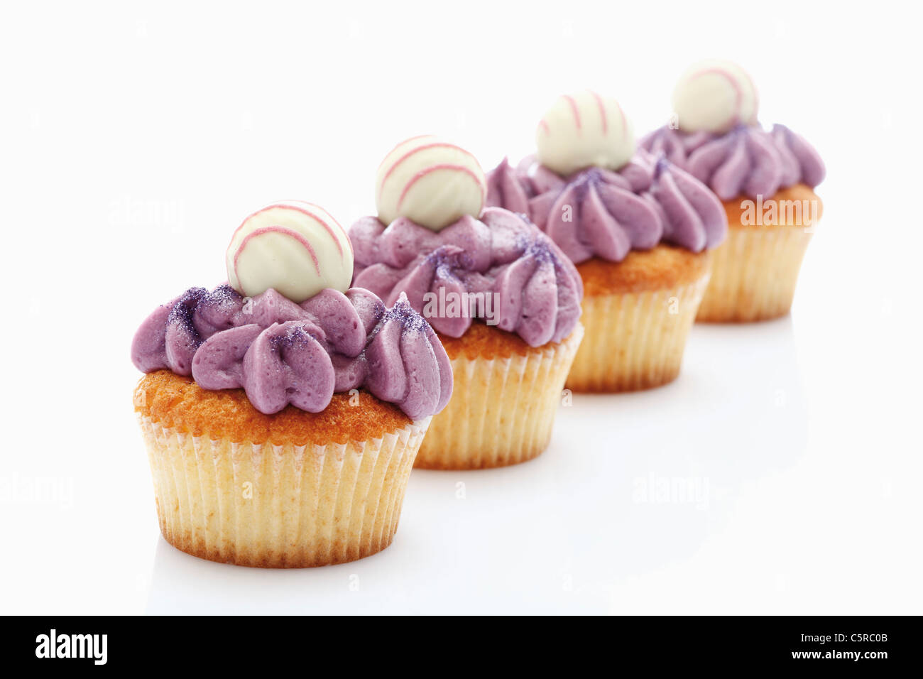 Close up de buttercream Groseillier noir truffe au chocolat cupcake avec against white background Banque D'Images