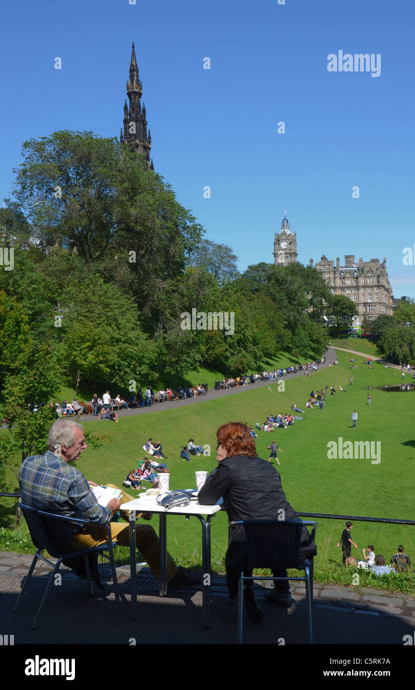 Un couple prendre un café et admirer la vue sur les jardins de Princes Street en direction du Scott Monument et de l'hôtel Balmoral. Banque D'Images