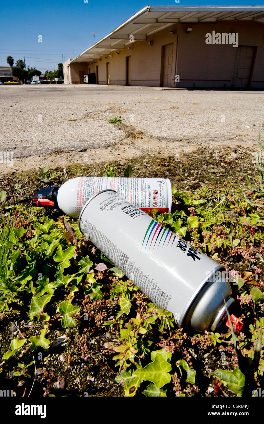 Les contenants vides de substances inhalées utilisés pour le trafic de "hauts" se situent dans un champ à côté d'une cour d'école à Santa Ana, CA. Banque D'Images
