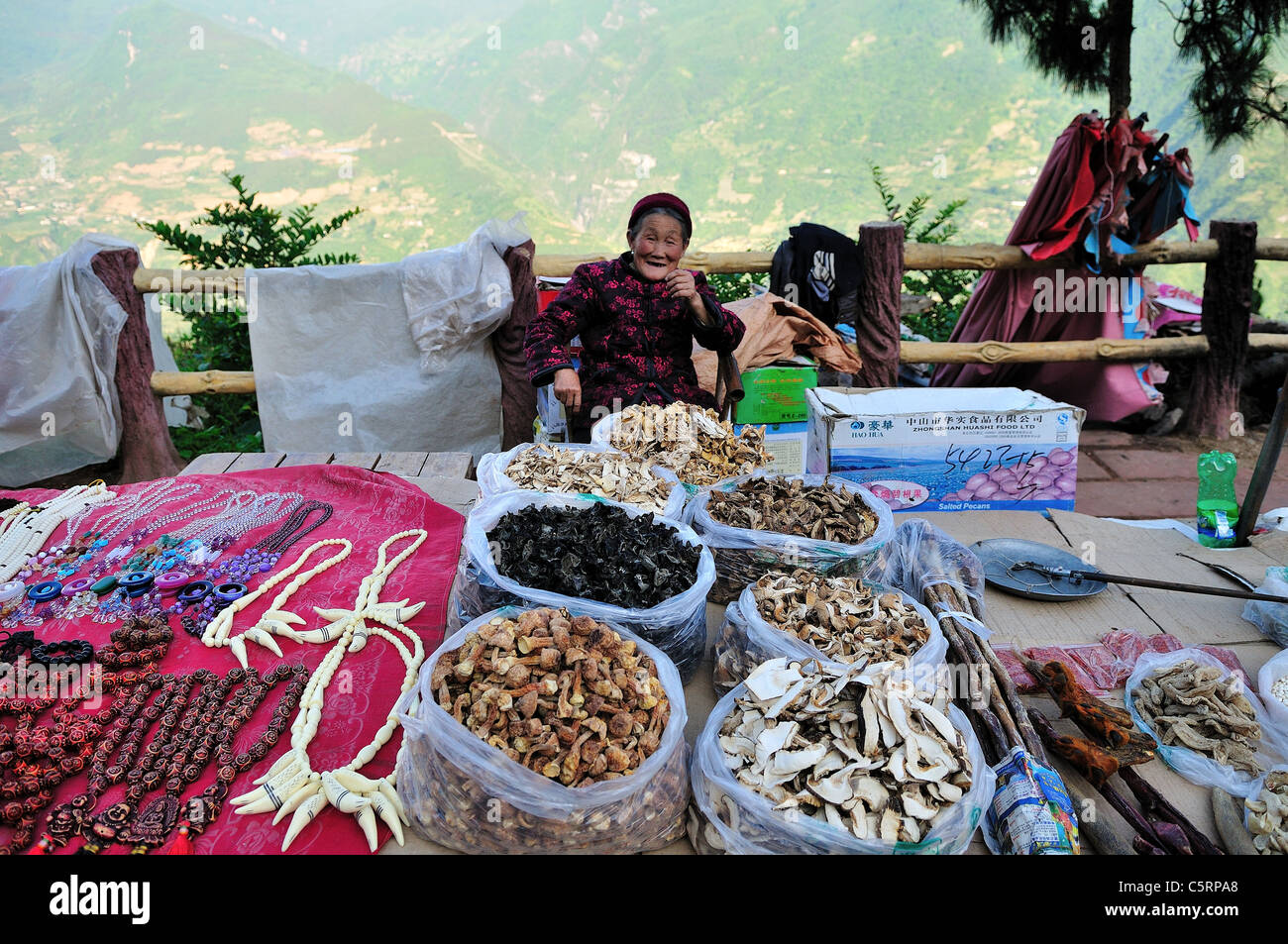 Vieille Femme vendant des produits locaux à un côté de la route d'un décrochage. Au Sichuan, en Chine. Banque D'Images