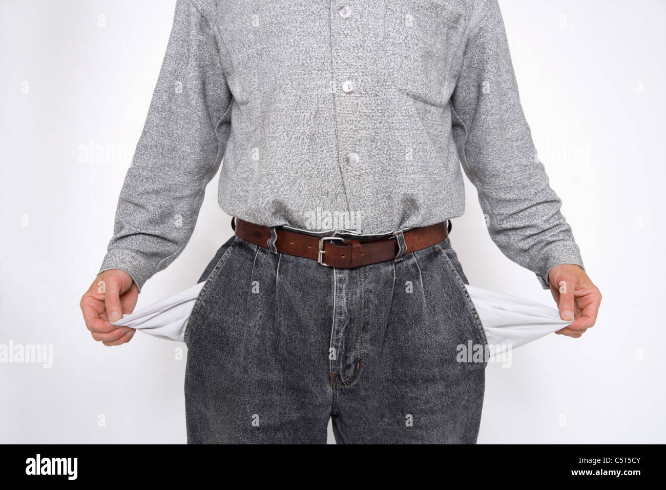 Close up of mature man holding empty pockets against white background Banque D'Images