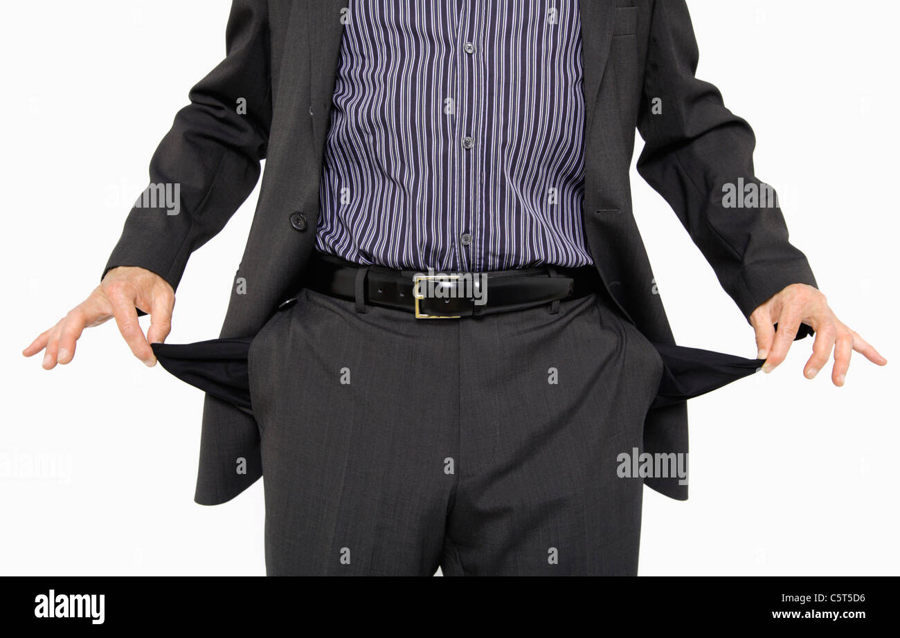 Close up of mature man holding empty pockets against white background Banque D'Images