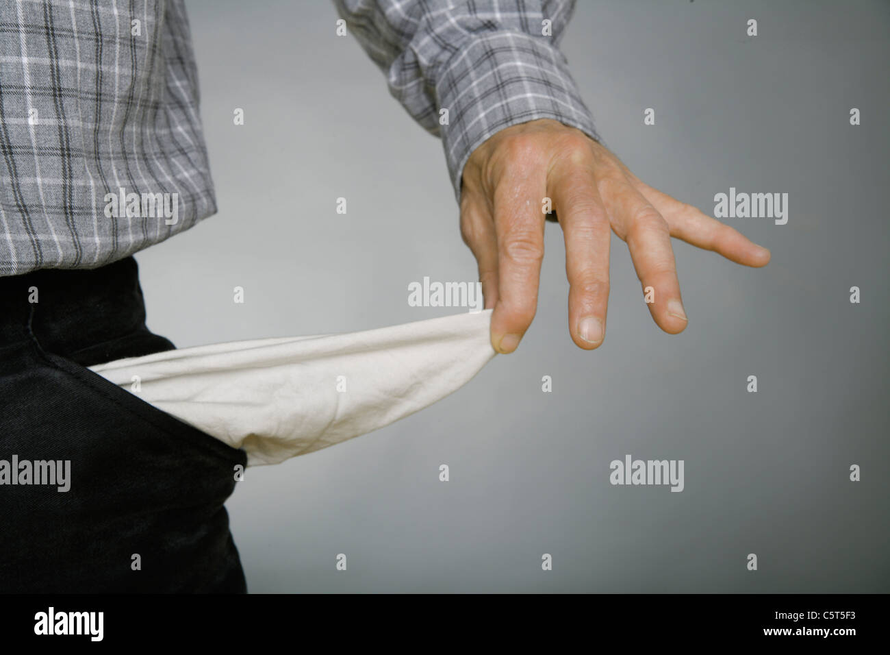 Close up of mature man holding poches vides à l'arrière-plan gris Banque D'Images