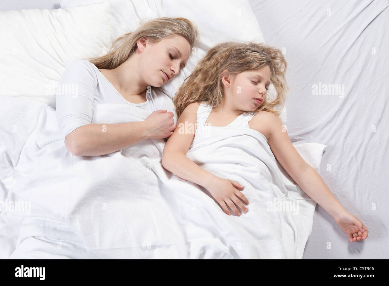 Germany, Bavaria, Munich, Mère et fille dormir sur le lit Banque D'Images