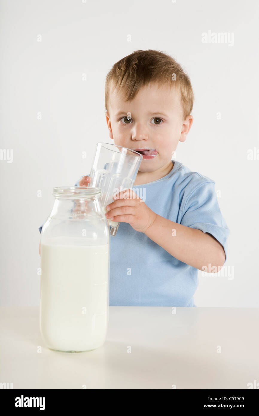 Boy (2-3) de boire un verre de lait, portrait Banque D'Images