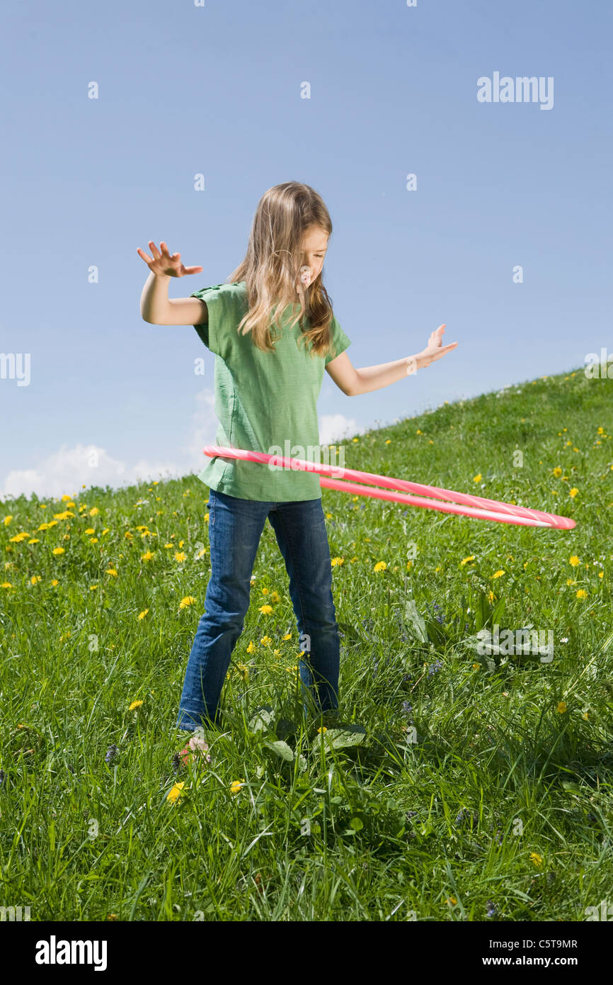 Germany, Bavaria, Munich, Girl (6-7) Playing with hula-hoop Banque D'Images