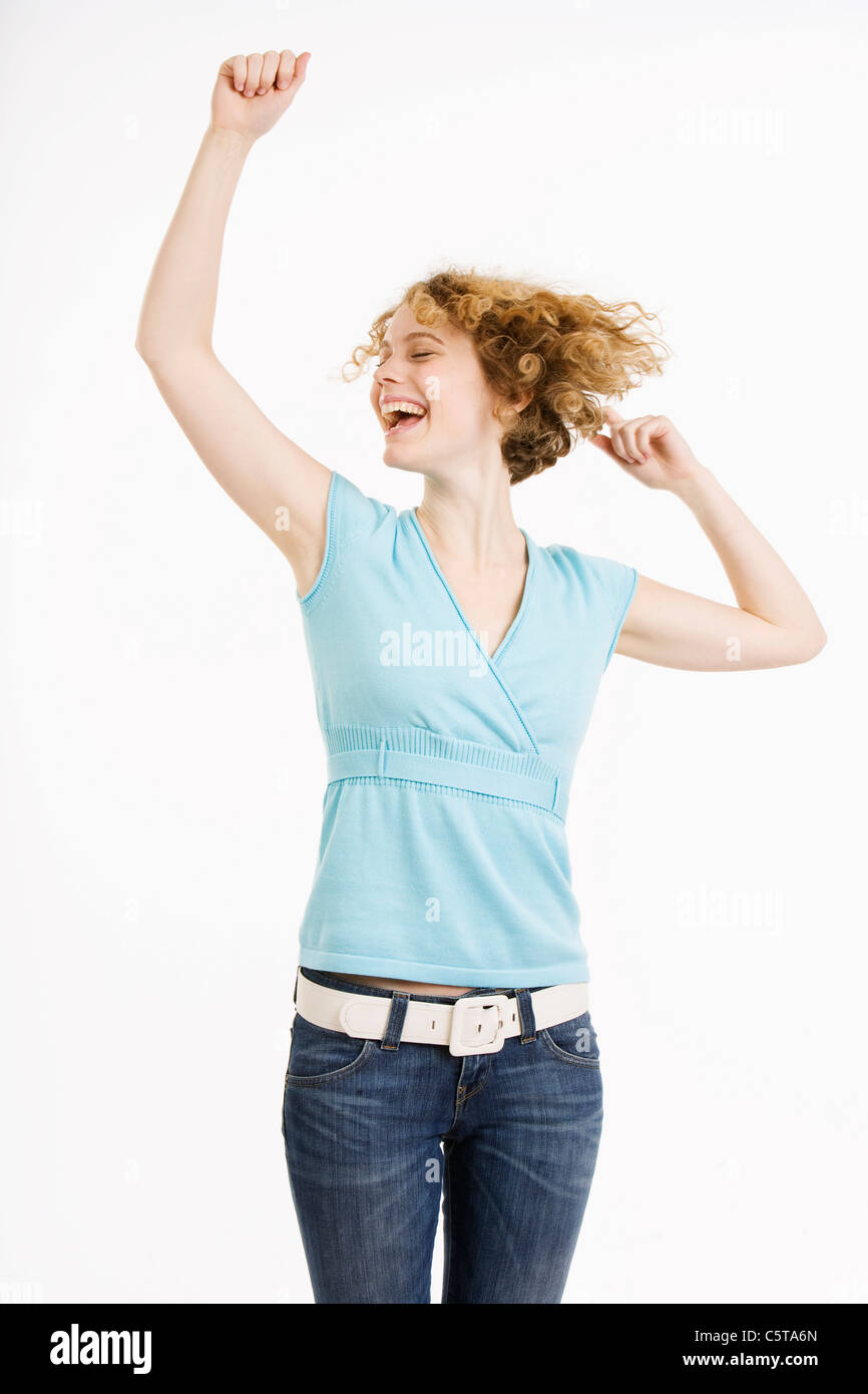 Young woman raising arms, joyeux, portrait Banque D'Images