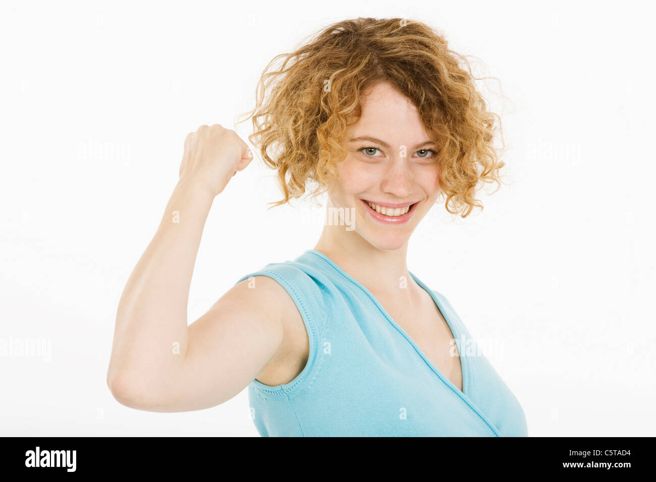 Young woman making fist, smiling, portrait Banque D'Images