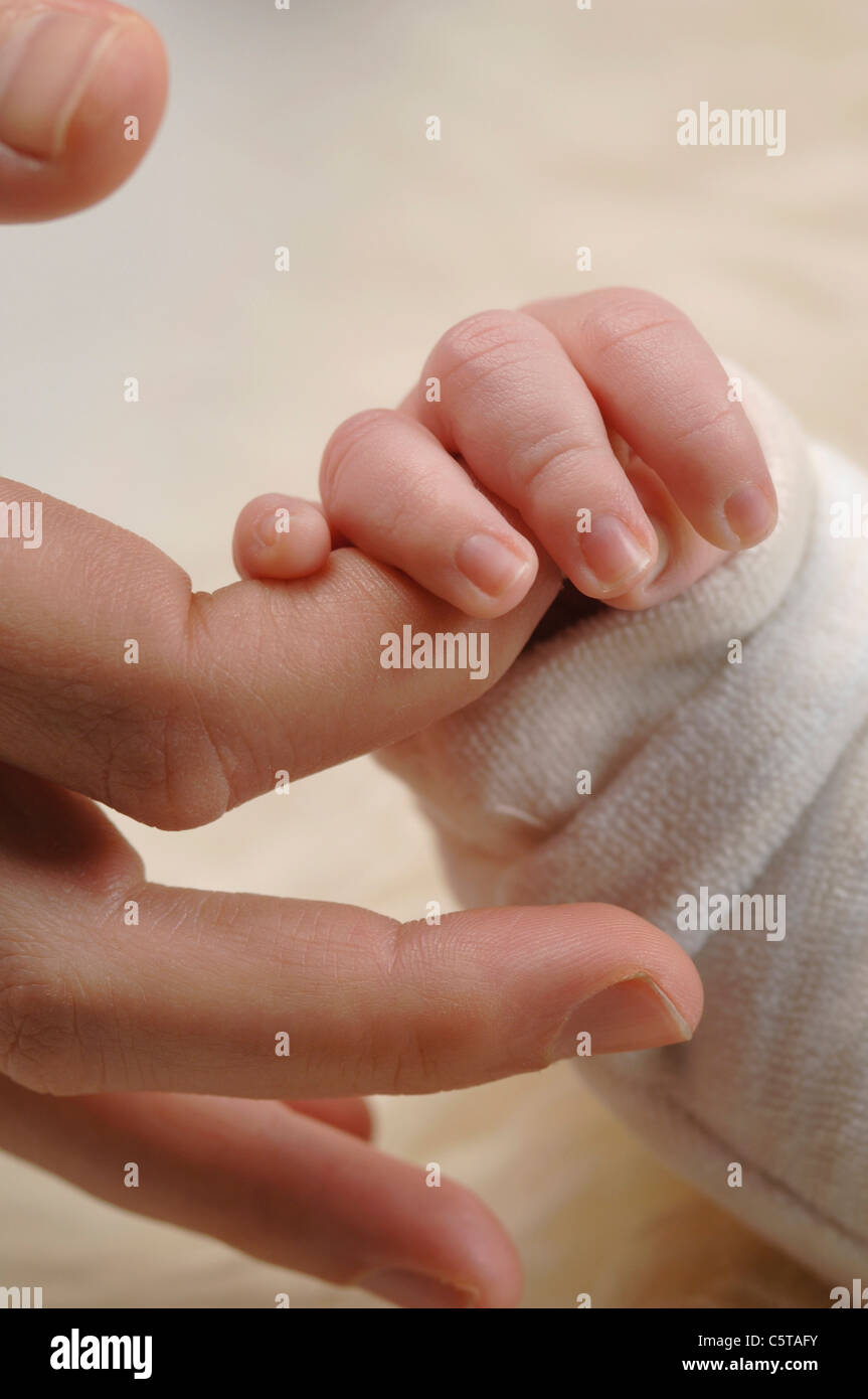 Germany, Bavaria, Munich, Baby Boy (3 semaines) du doigt de maintien, Close up Banque D'Images