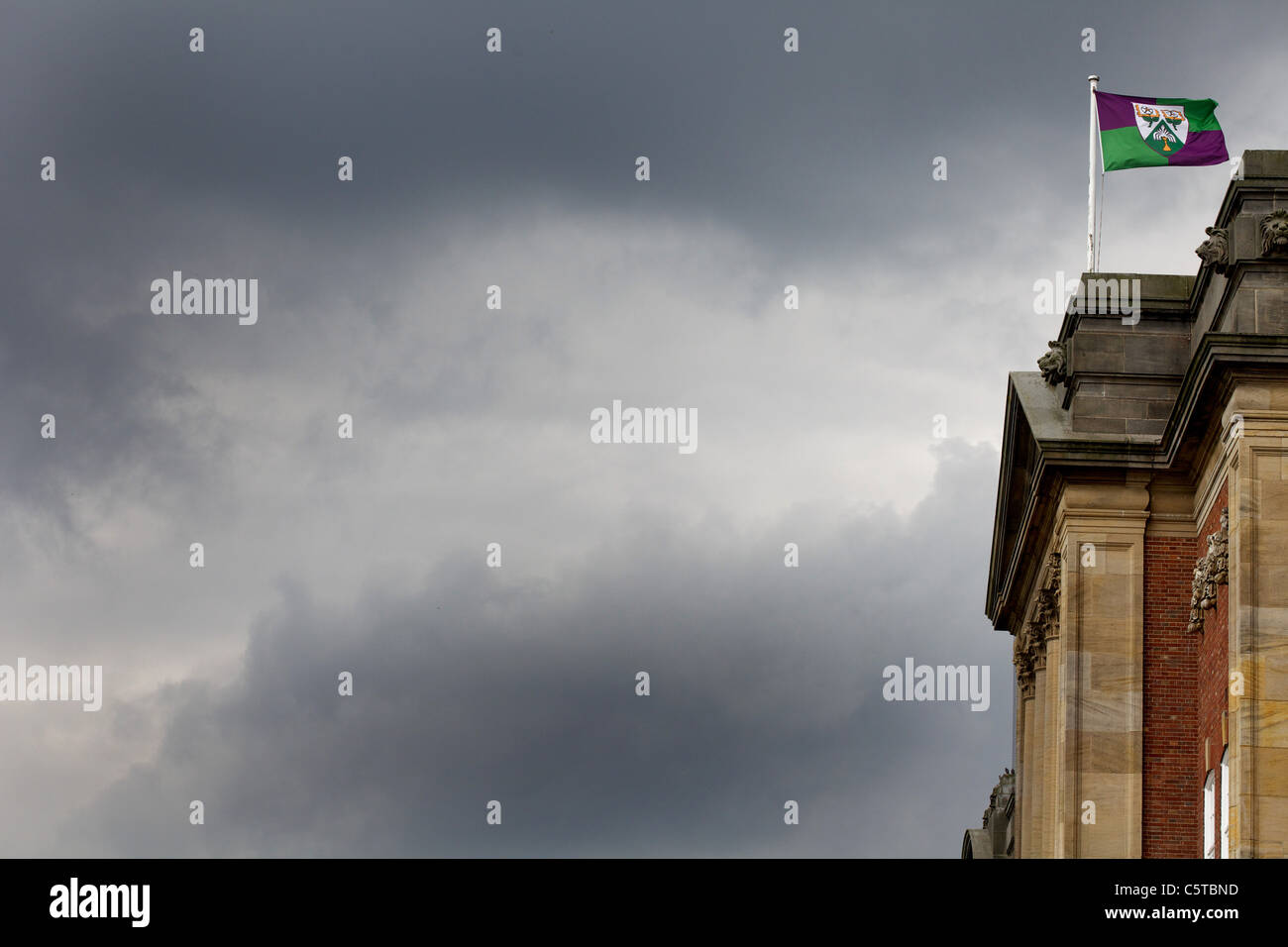 Armoiries drapeau flottant dans un ciel gris au-dessus de James Graham, 7e année de construction 11 répertoriées. L'Université Métropolitaine de Leeds, Headingley Banque D'Images