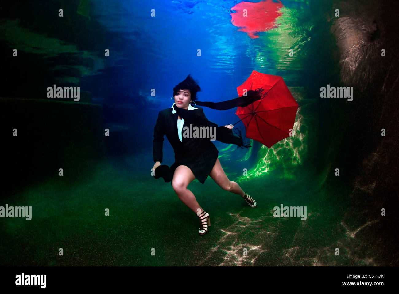 Femme tenant un parapluie sous l'eau Banque D'Images