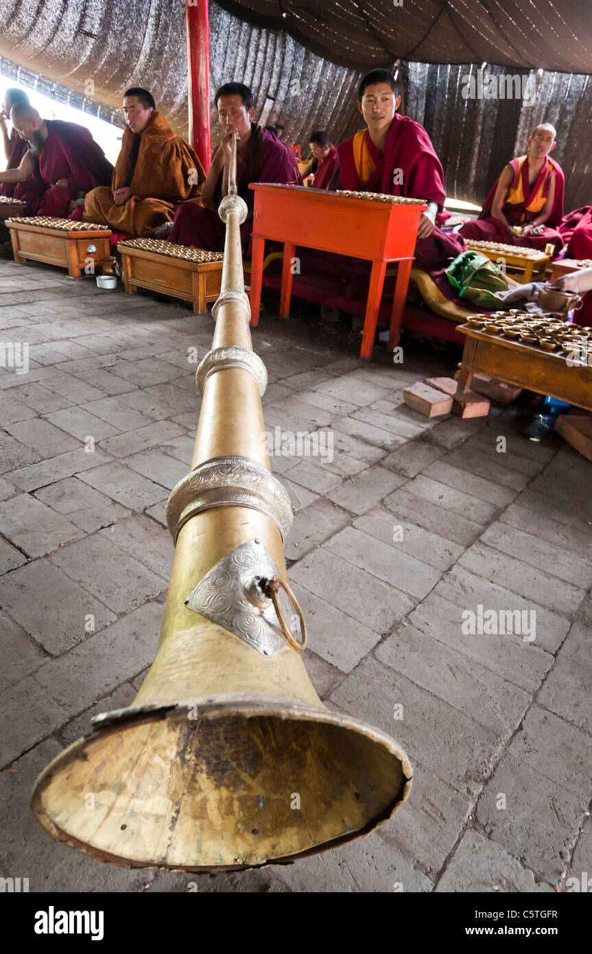 Moine bouddhiste tibétain joue tongren long horn, Arou Temple Ba, Qilian, Province de Qinghai, Chine Banque D'Images