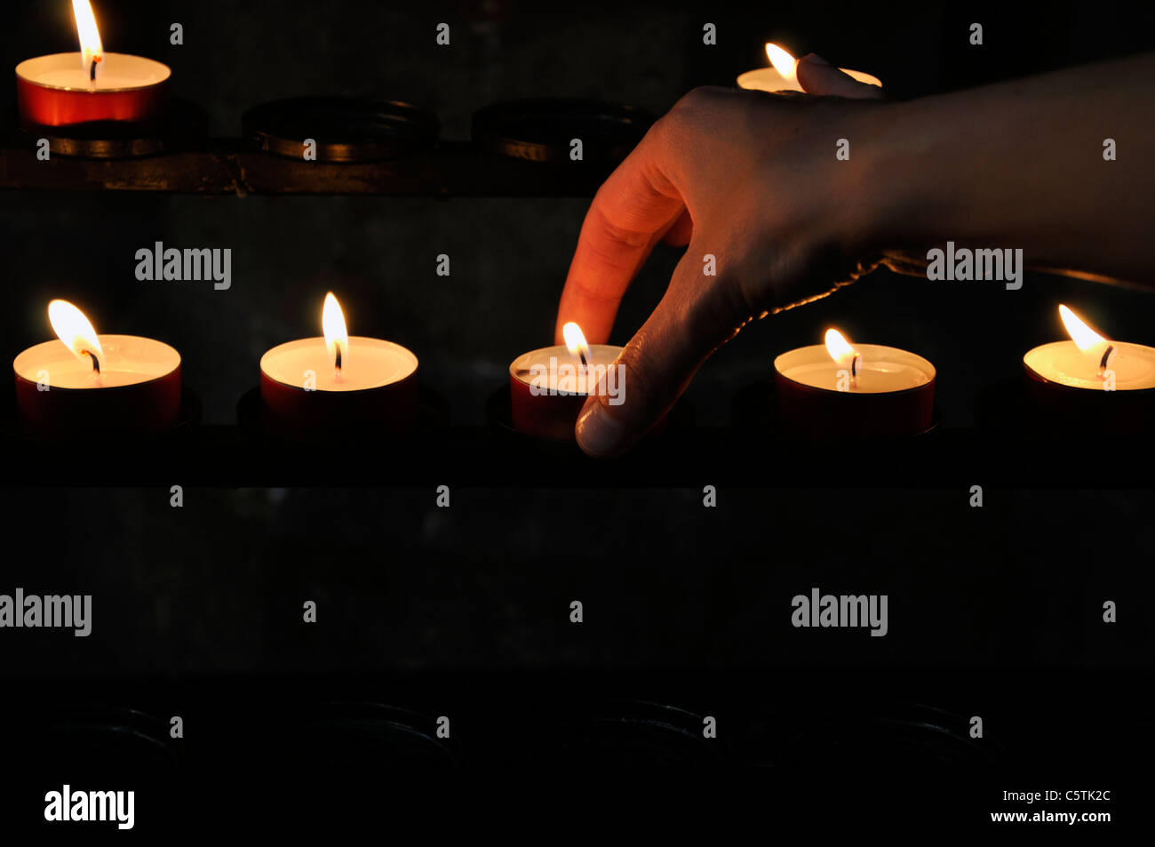 Jeune femme allumant des bougies à l'église de Vienne, Autriche, Europe Banque D'Images