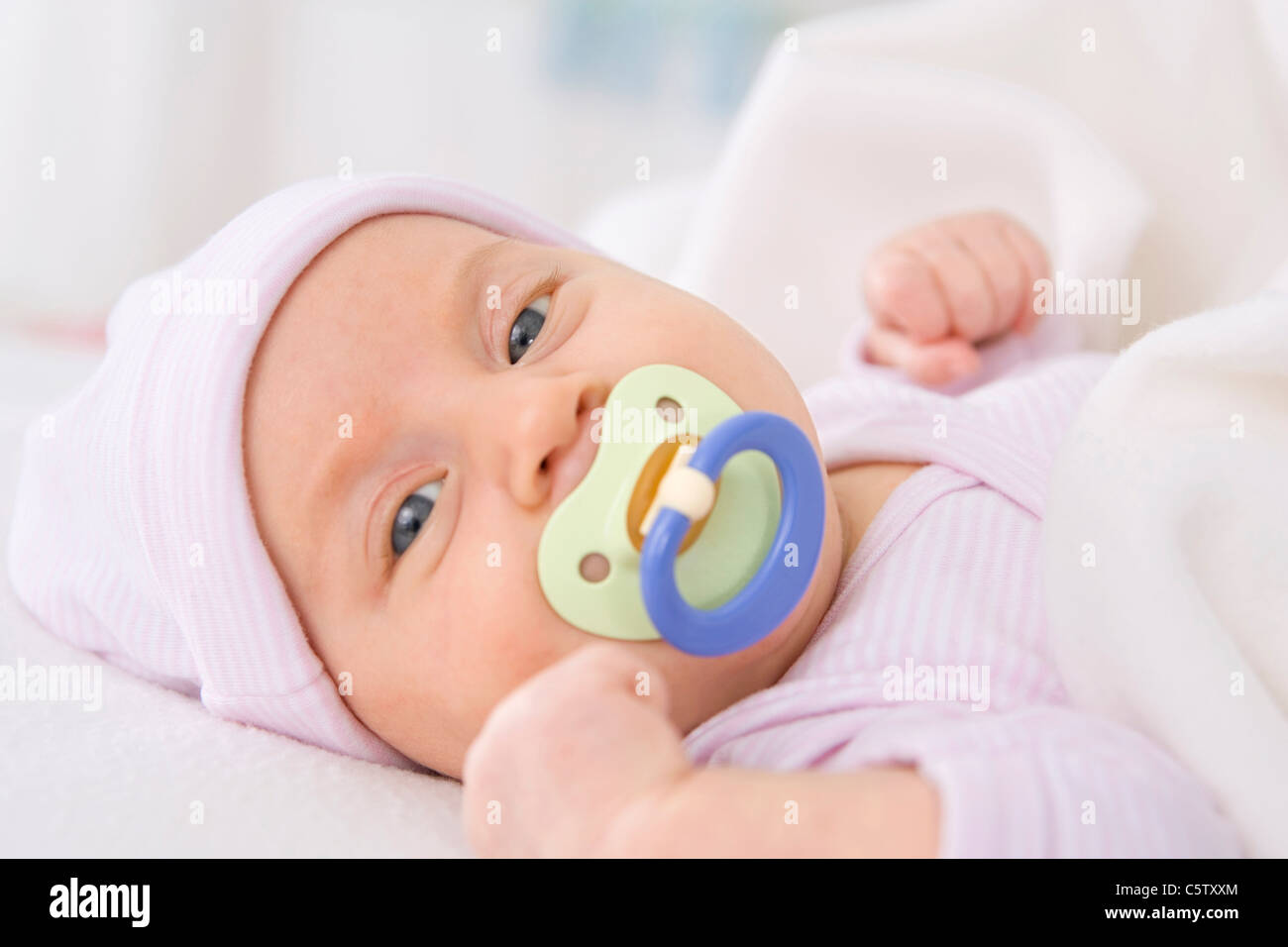 Bébé fille (2 mois) avec tétine, portrait Banque D'Images