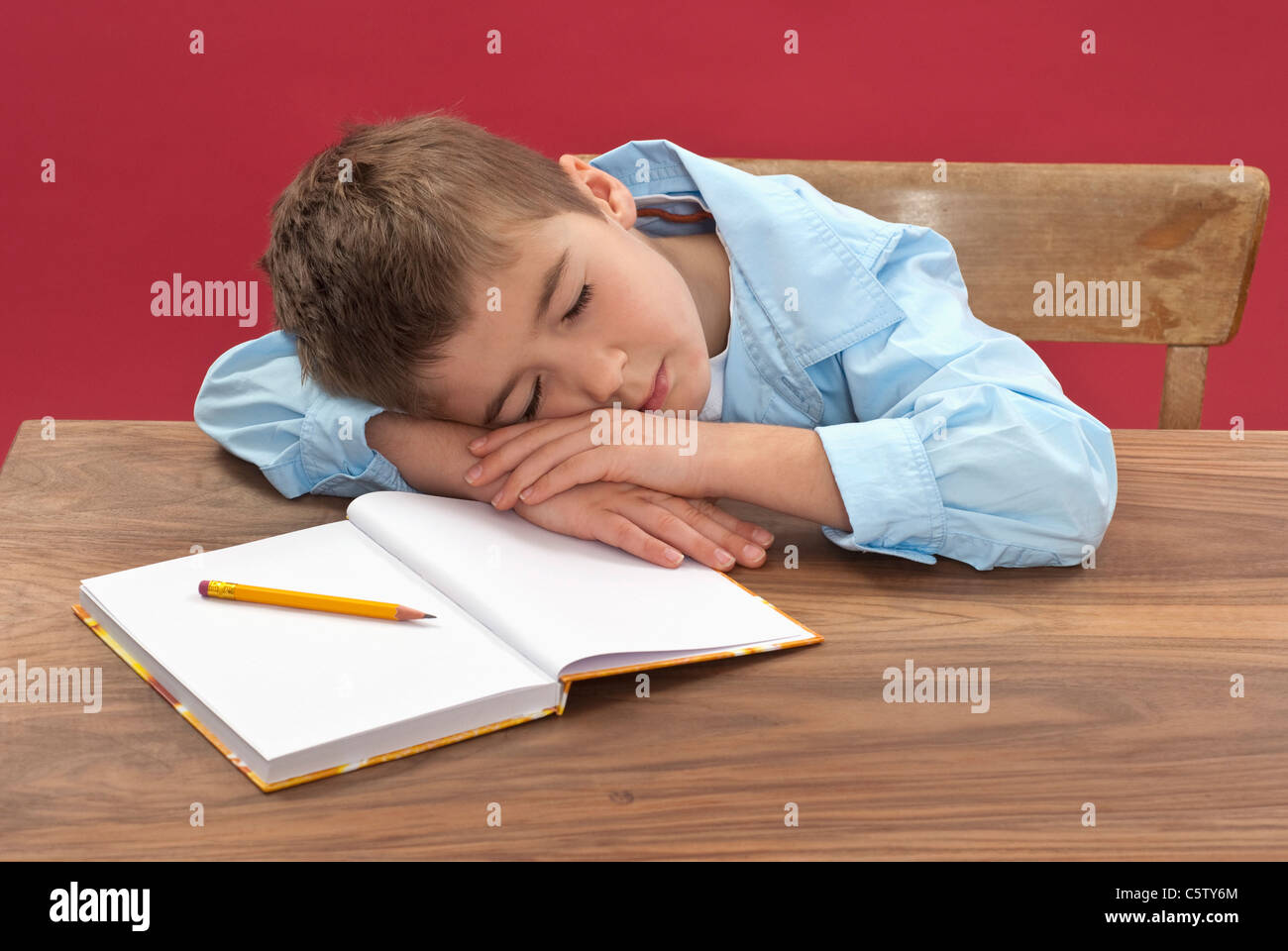 Schoolboy (6-7) sleeping at desk Banque D'Images