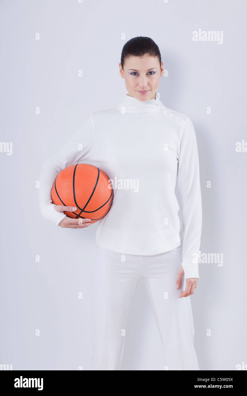 Mid adult woman with basket ball against white background, smiling, portrait Banque D'Images