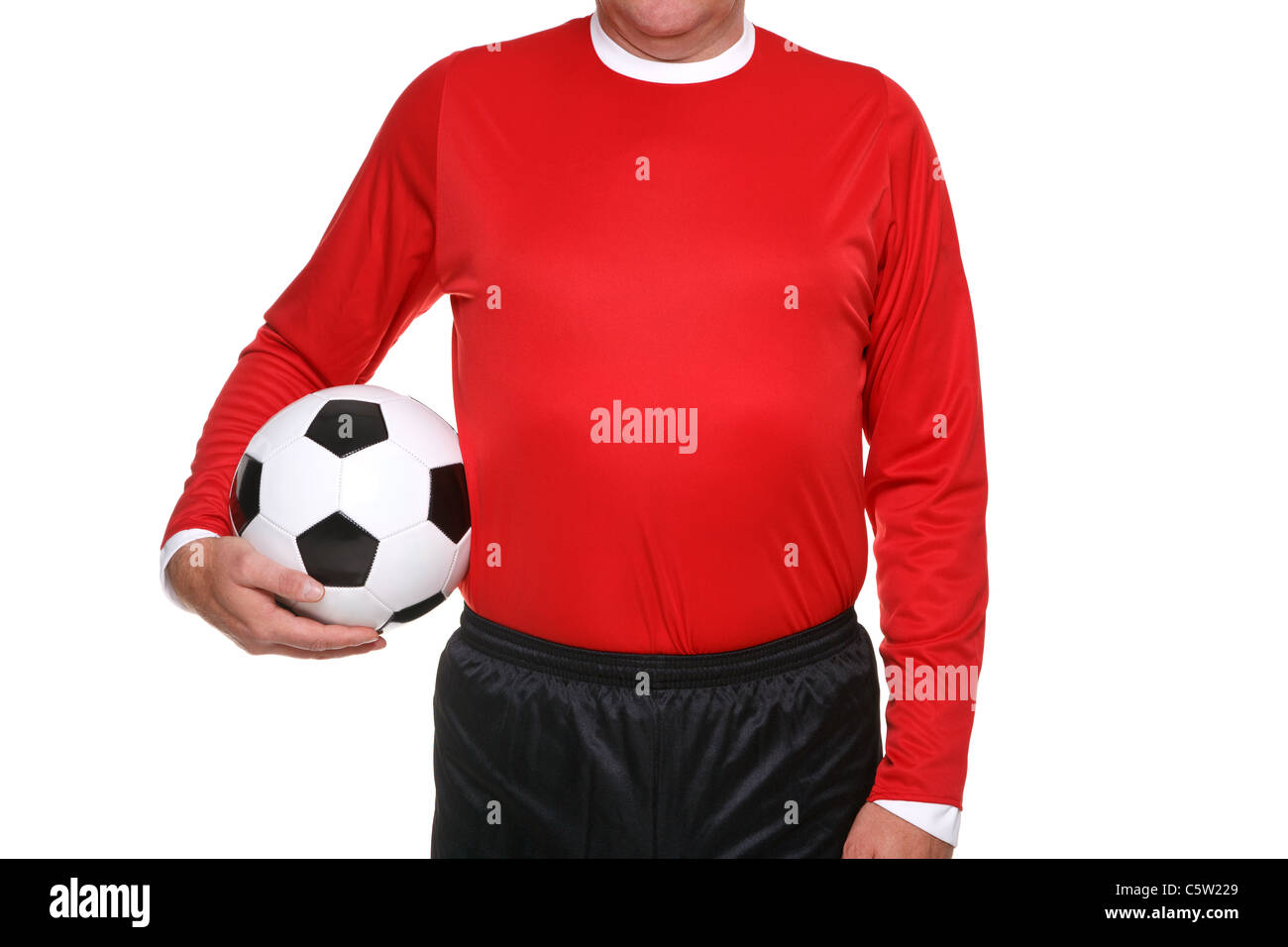 Photo d'un joueur de soccer ou de football tenant une balle à son côté, isolé sur un fond blanc. Banque D'Images