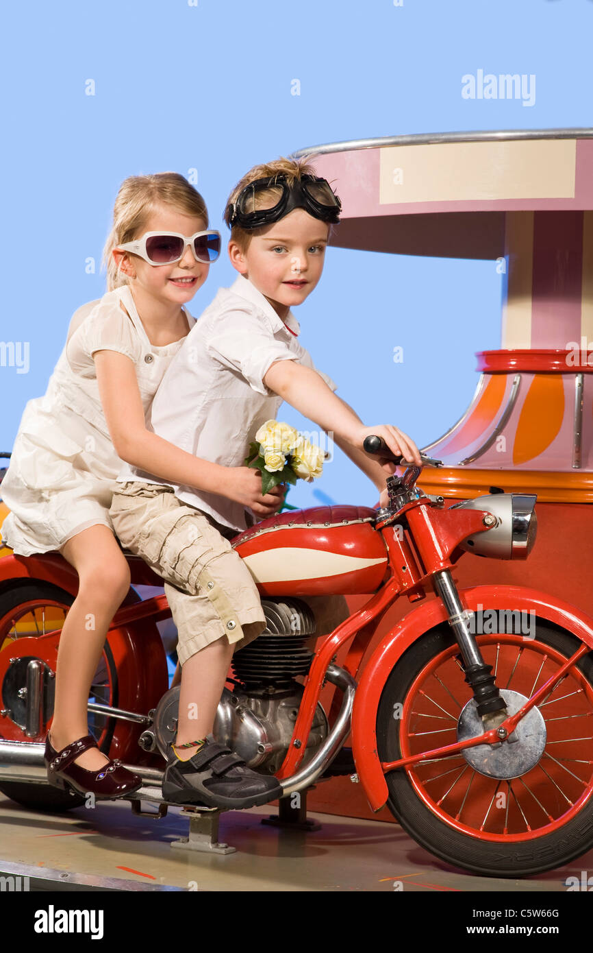 Allemagne, Landshut, boy and girl (4-5) équitation vélo carrousel Banque D'Images