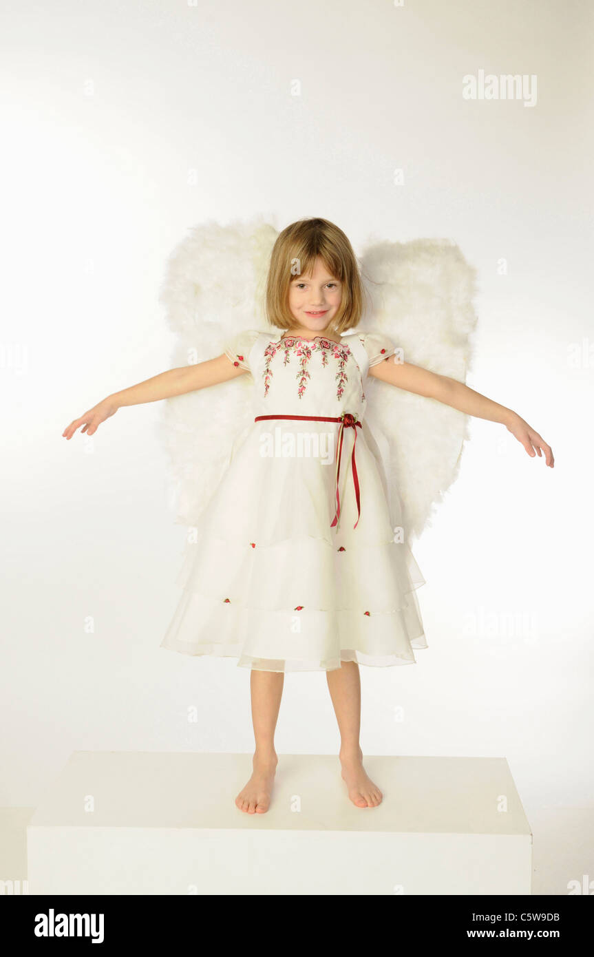 Little girl (6-7) wearing angel wings, les bras Banque D'Images