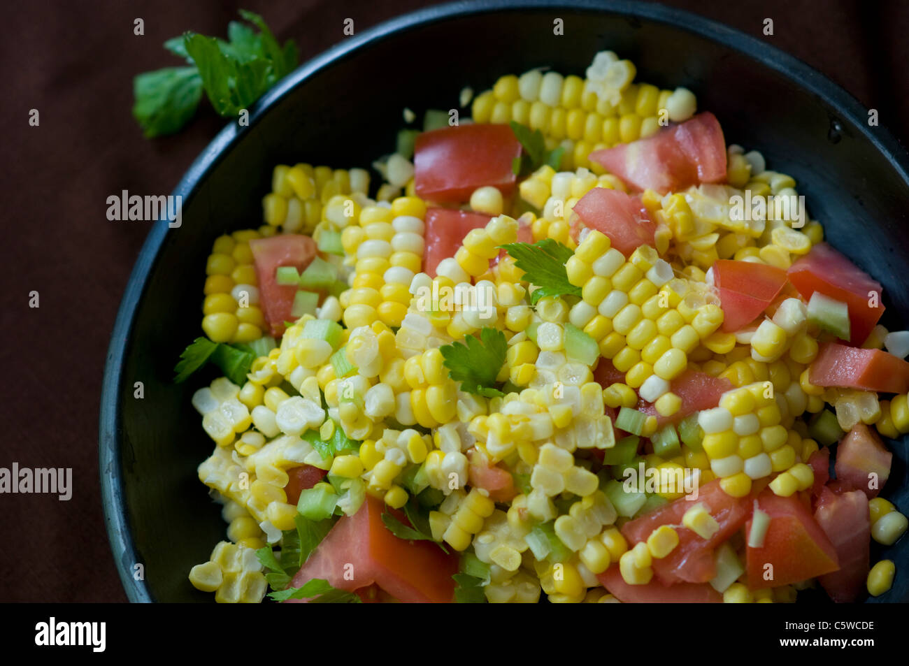 Salade de maïs frais dans un bol noir Banque D'Images