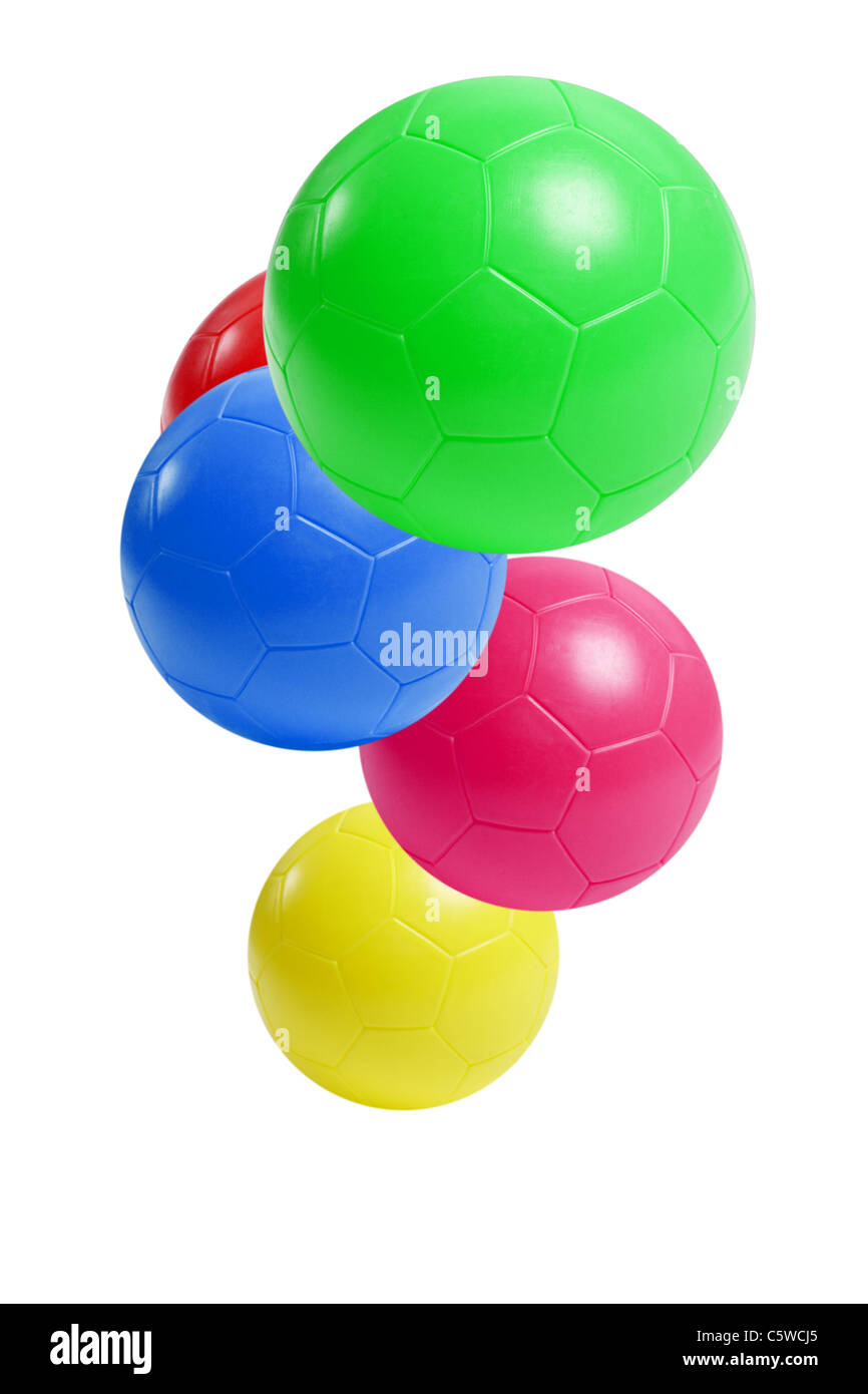 En plastique coloré ballons de soccer en suspension dans l'air sur fond blanc Banque D'Images