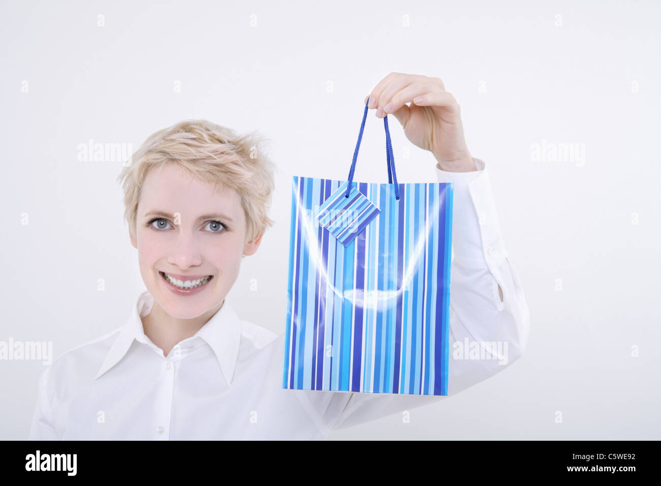 Woman holding gift bag, portrait Banque D'Images