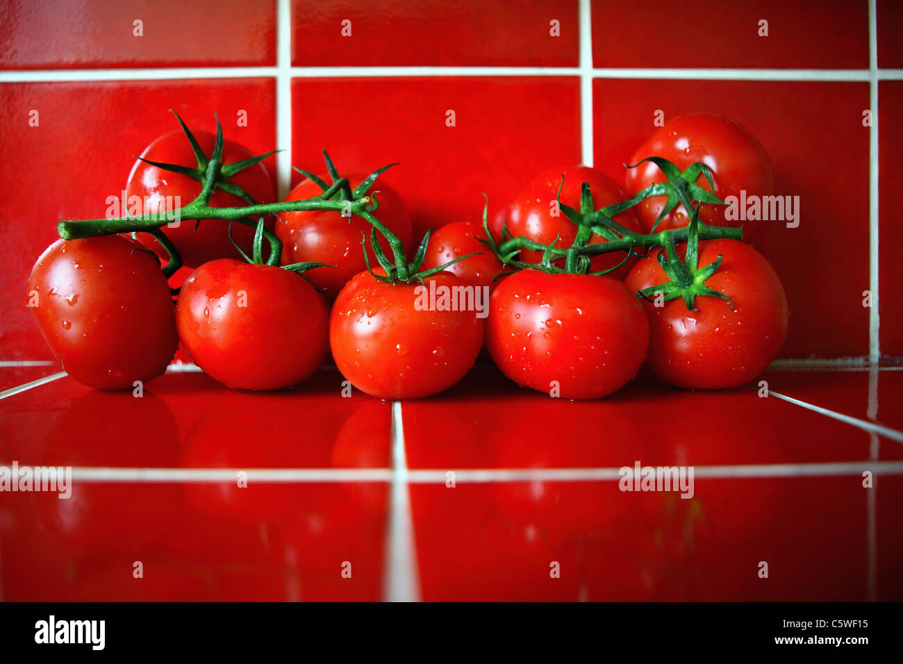 Les tomates fraîches sur les tuiles rouges dans la cuisine Banque D'Images