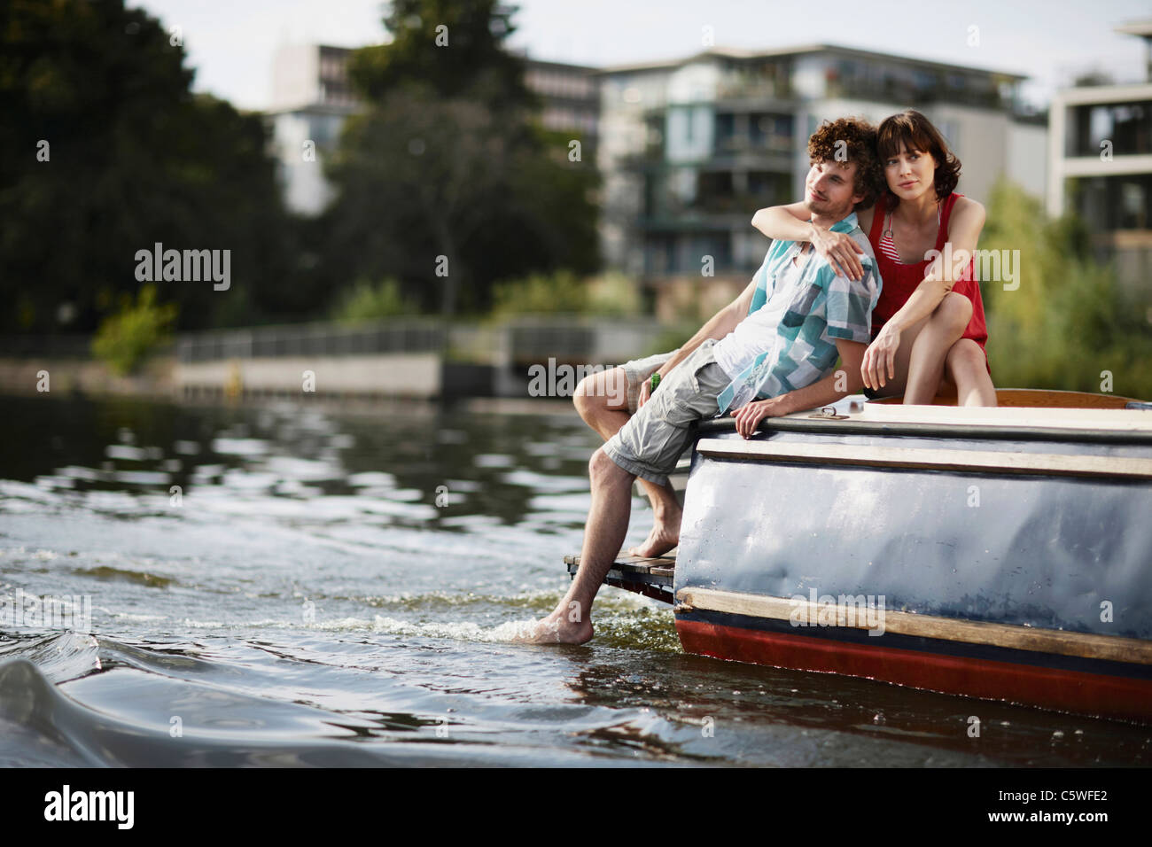 Allemagne, Berlin, Young couple sitting on motor yacht, portrait Banque D'Images