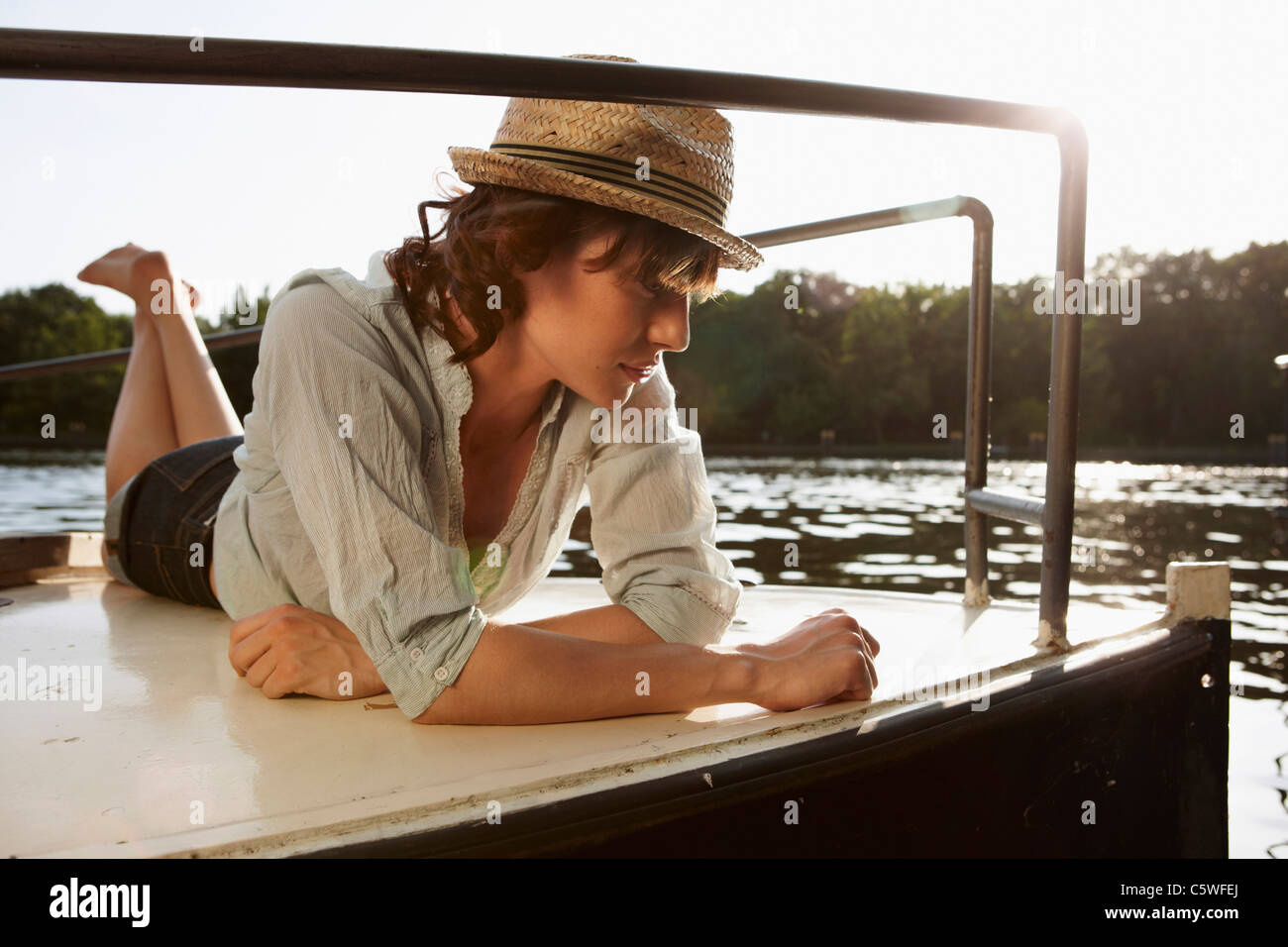 Allemagne, Berlin, young woman lying on motor yacht Banque D'Images