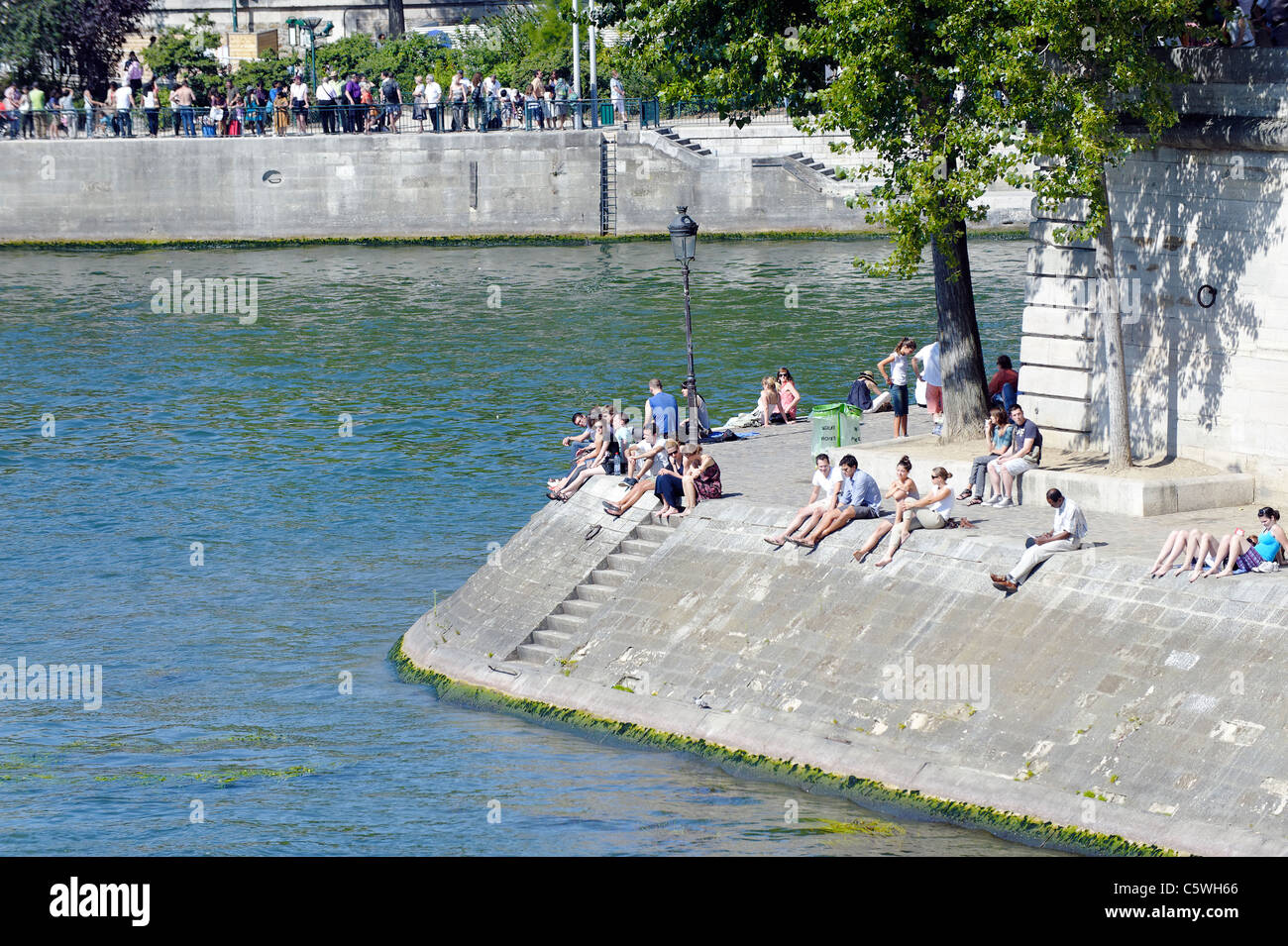 Les parisiens de soleil sur les rives de la rivière Seine Banque D'Images