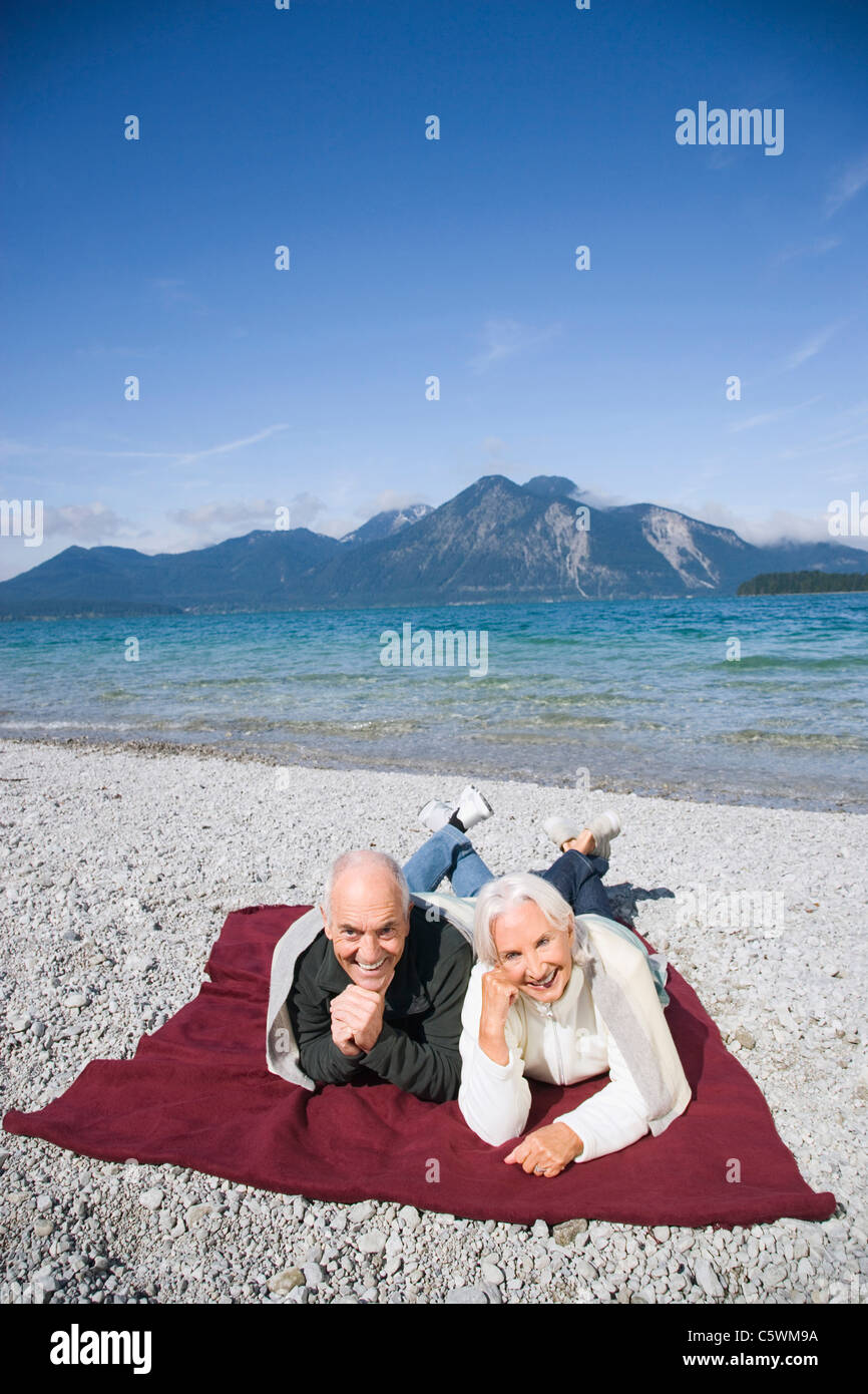Spain, Senior couple relaxing on lakeshore Banque D'Images