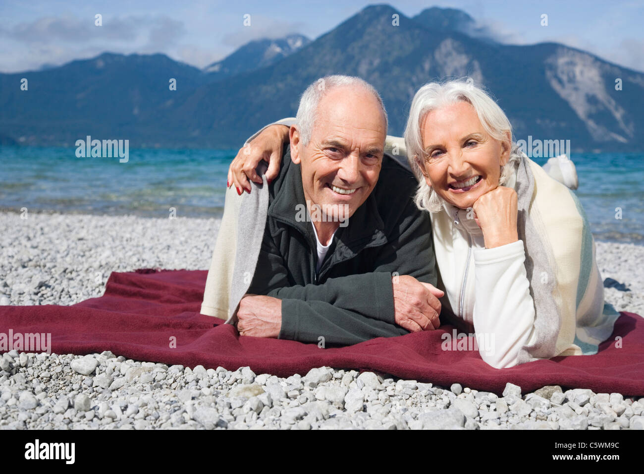 Spain, Senior couple relaxing on lakeshore Banque D'Images