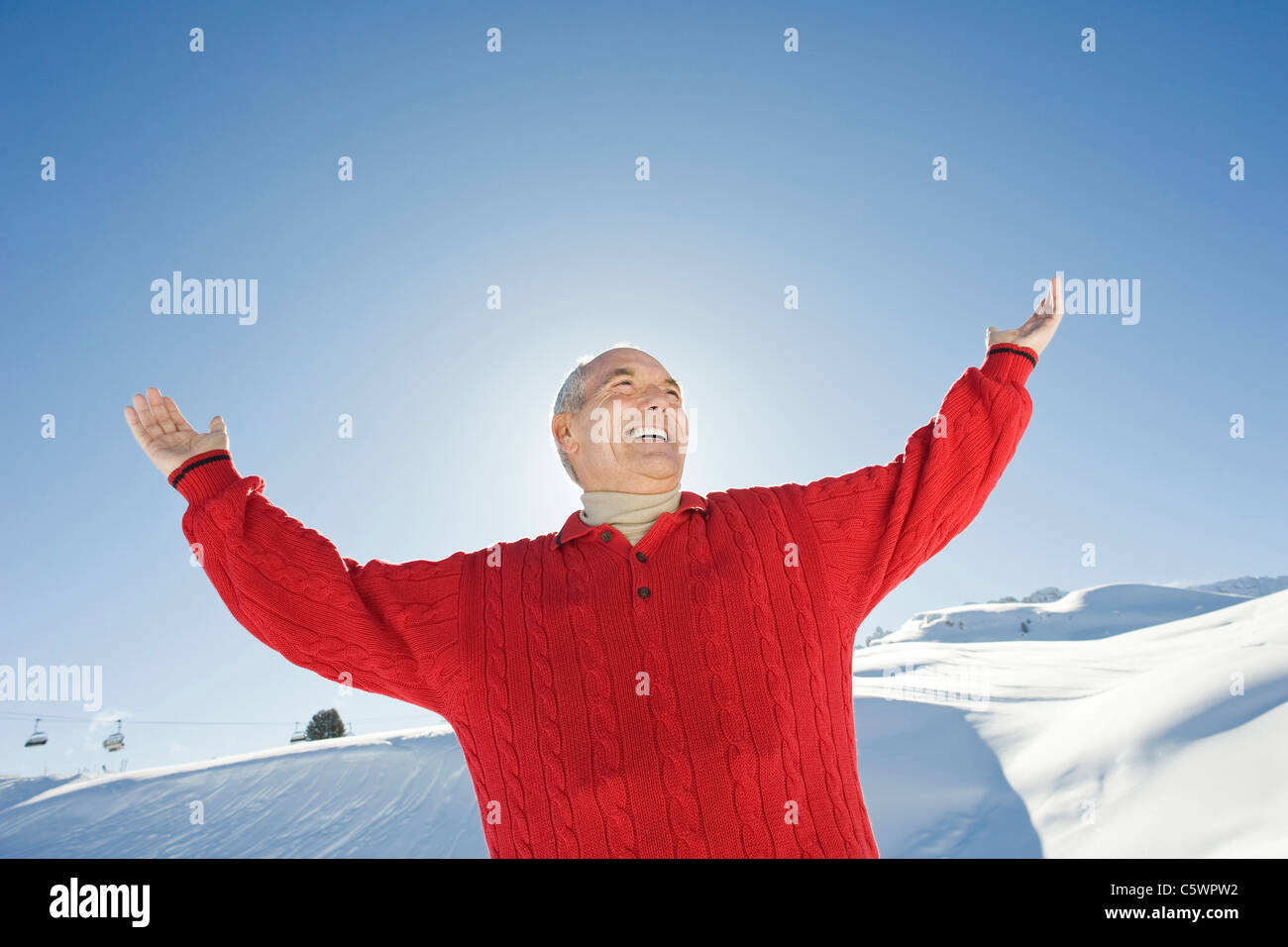 Germany, Berlin, young man raising arms, smiling, portrait Banque D'Images