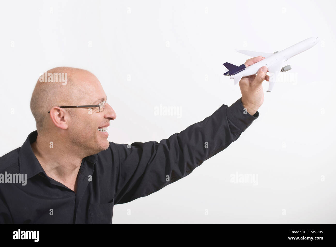 Businessman holding toy plane Banque D'Images