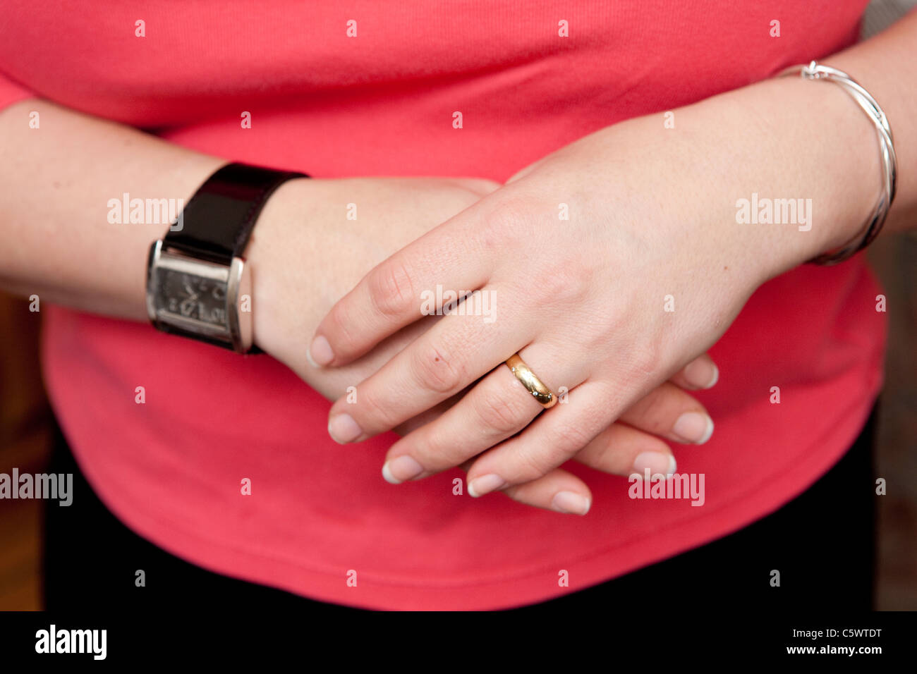 Une femme au foyer ses mains avec de l'anneau de mariage et bracelet montre  Photo Stock - Alamy