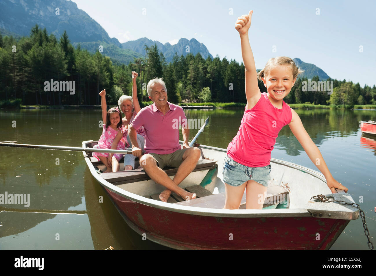 L'Italie, le Tyrol du Sud, grands-parents et enfants (6-7) (8-9) en bateau à rames sur le lac, portrait Banque D'Images