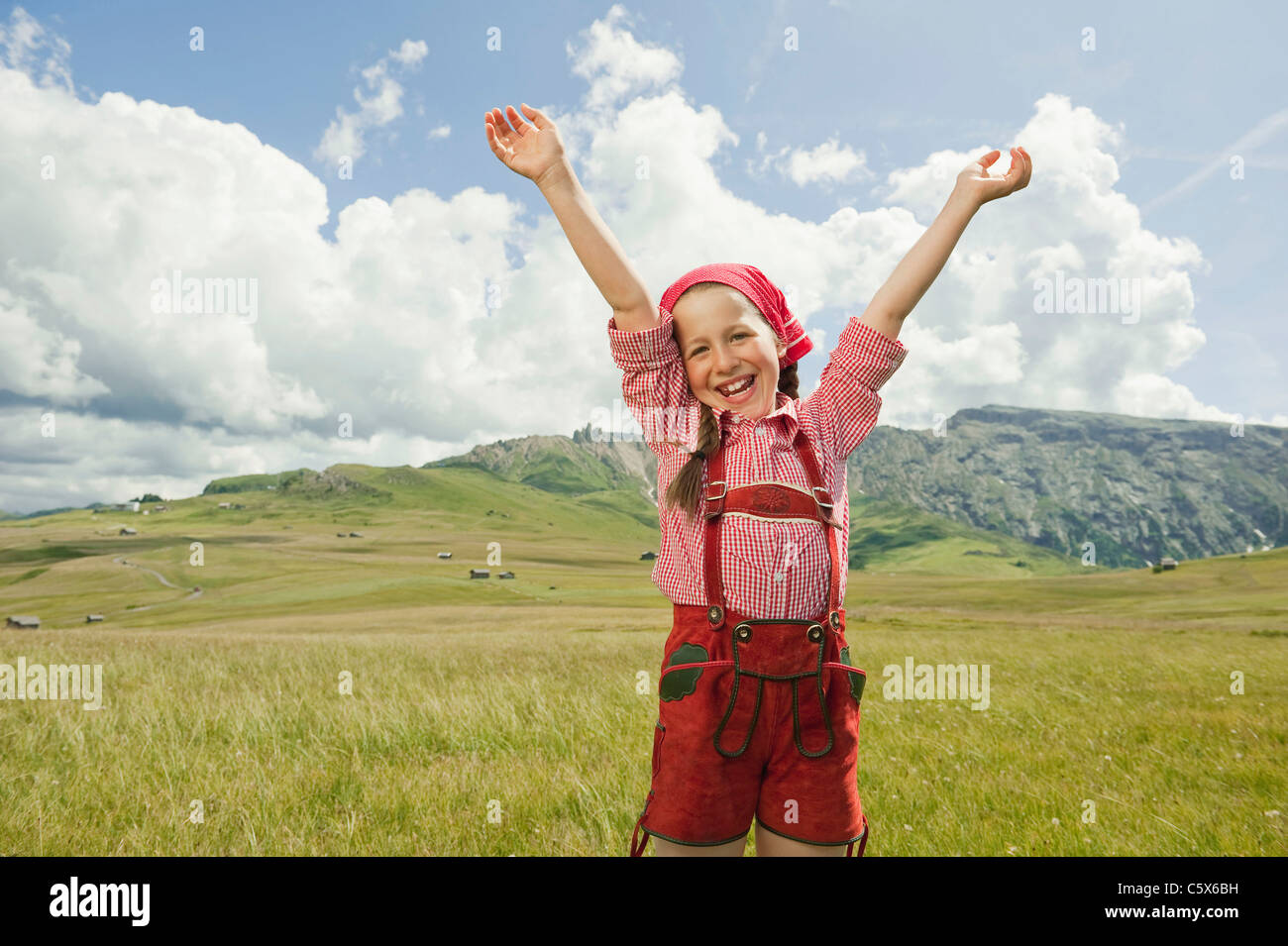 Allemagne, Berlin, Girl (8-9) in meadow, acclamant les bras, portrait Banque D'Images