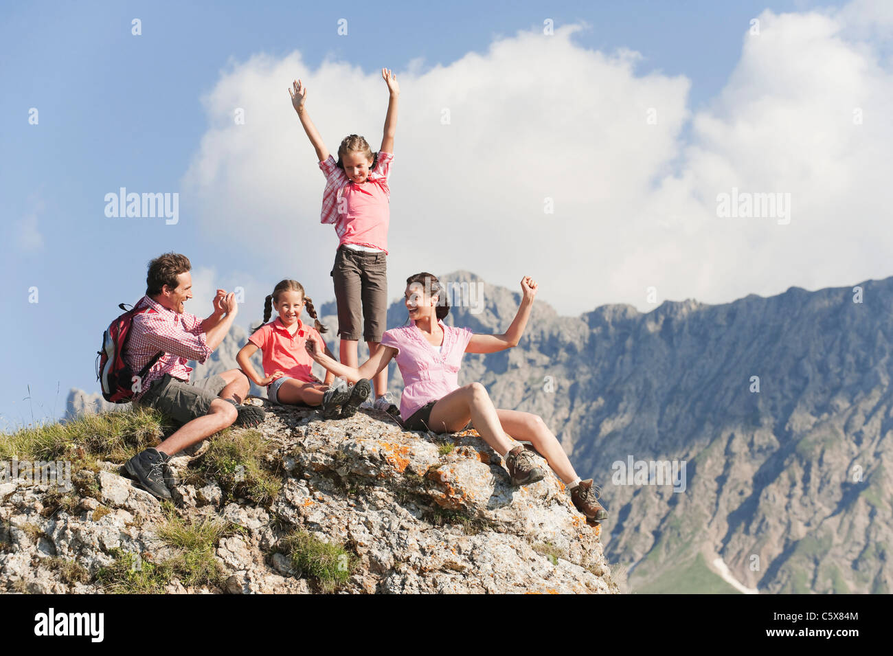 L'Italie, le Tyrol du Sud, Family sitting on rock, man taking photo Banque D'Images