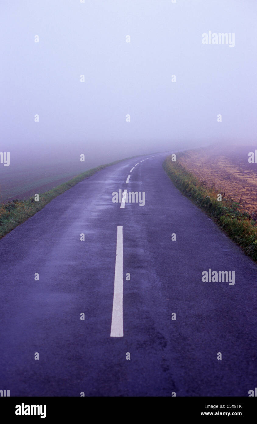 Empty country road dans un épais brouillard uk Banque D'Images