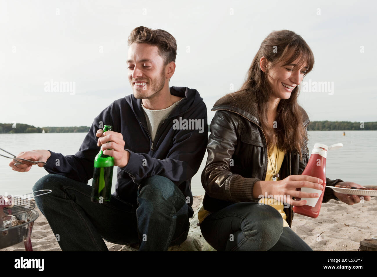 Allemagne, Berlin, le lac de Wannsee, Young couple having a barbecue Banque D'Images