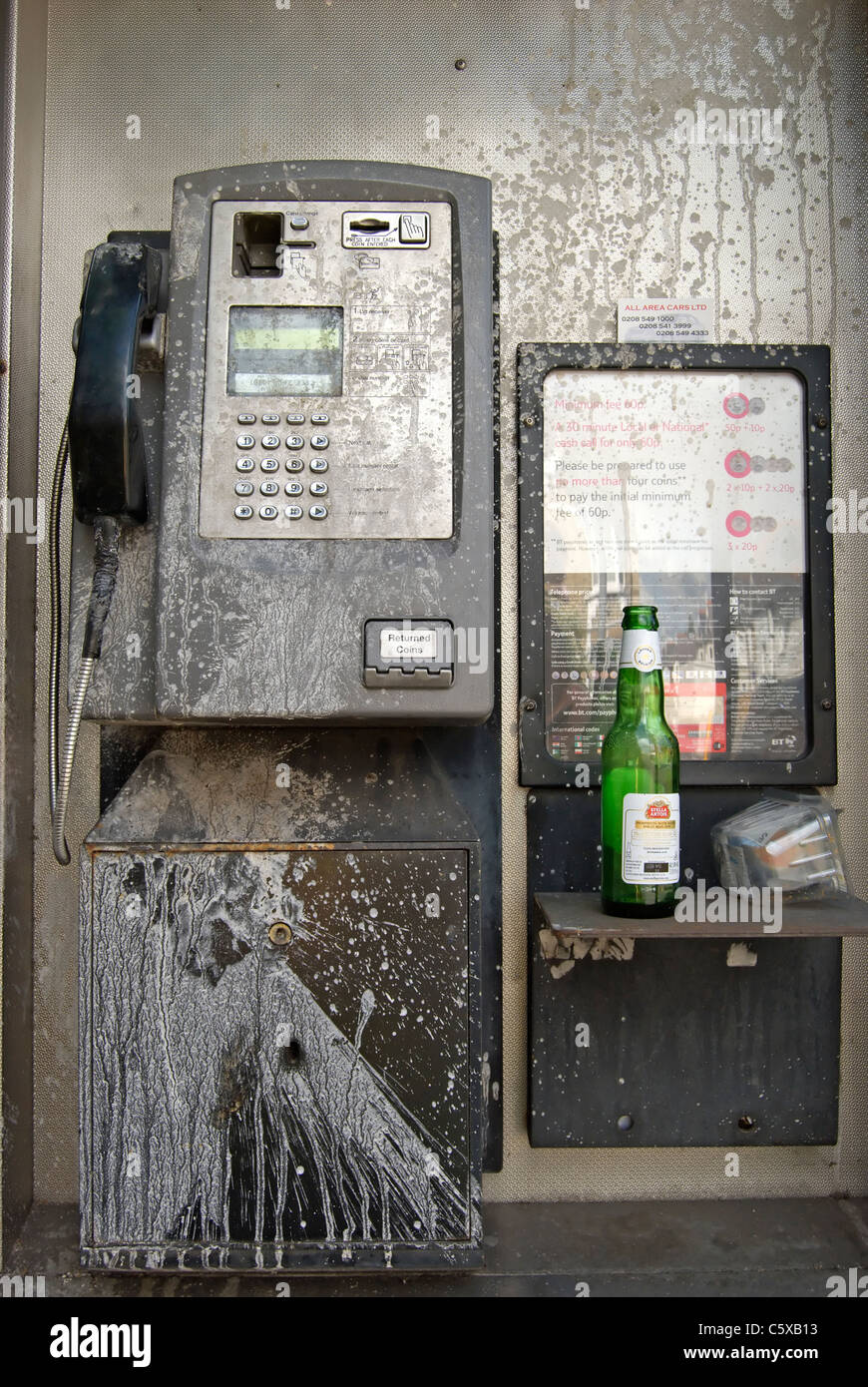 Cabine téléphonique publique britannique barbouillés avec peinture blanche et avec les ordures, à Kingston upon Thames, Surrey, Angleterre Banque D'Images