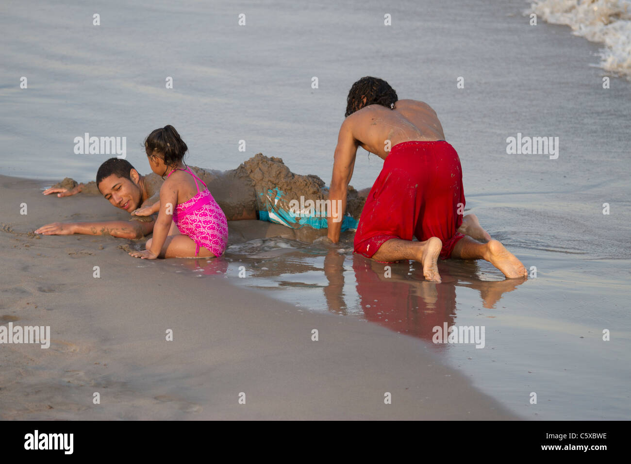 Enfants jouant dans le sable humide à Coney Island Beach sur une chaude après-midi de printemps Banque D'Images