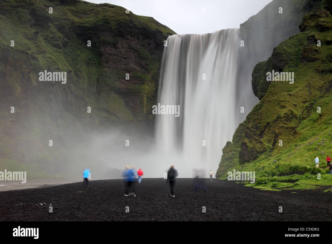 Les touristes en dessous du 200ft (61m) Haute Cascade Skogafoss Skogar Islande Banque D'Images