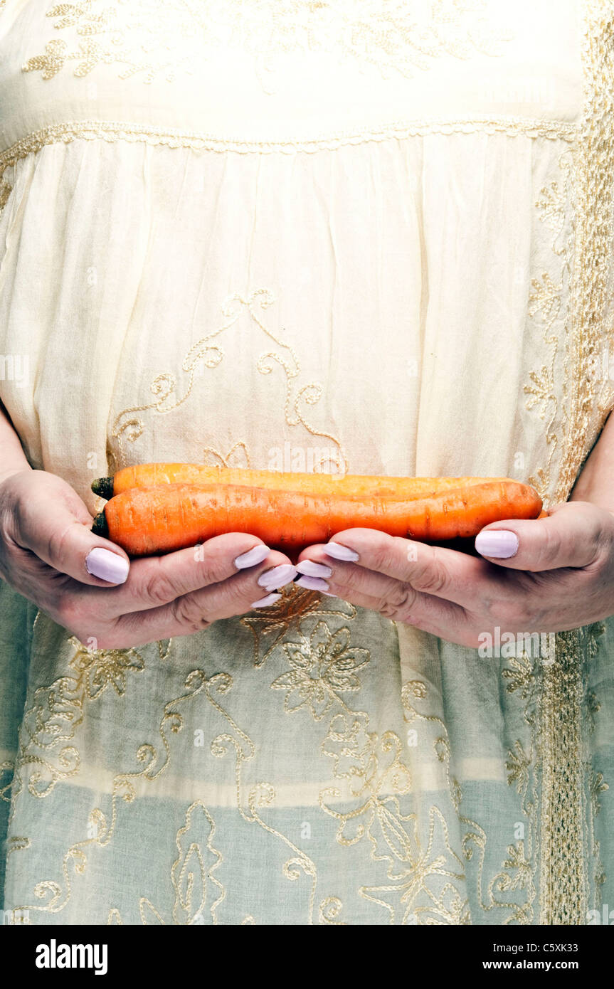 De carottes à la main femme Banque D'Images