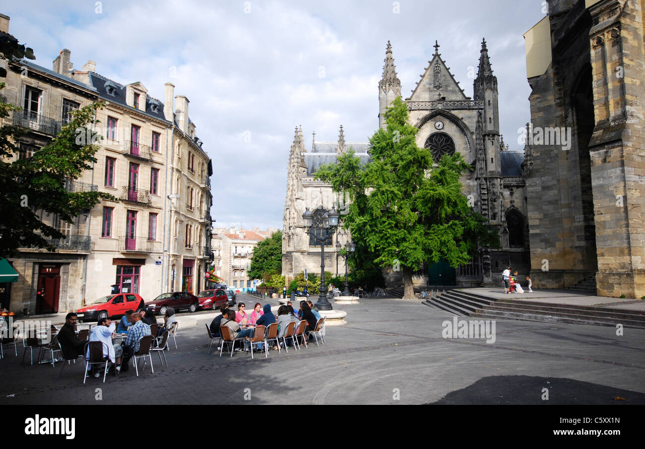 Les gens se détendre dans les restaurants sur place Meynard par la majestueuse église médiévale basilique Saint-Michel à Bordeaux, France. Banque D'Images